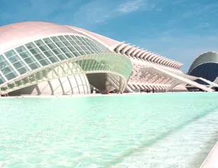A pale tiled walkway beside a turquoise reflecting pool, with a domed hall and a slender white mast beyond.