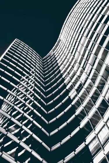 The curving steel lattice of Trinity Bank Tower rising against a deep teal sky.