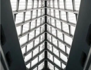 Looking up into Netcry Tower's white atrium roof, its glazed lattice fanning out from a curved beam.