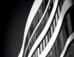 The banded facade of SXIV Tower curving away in black and white, ribbon windows following the sweep.